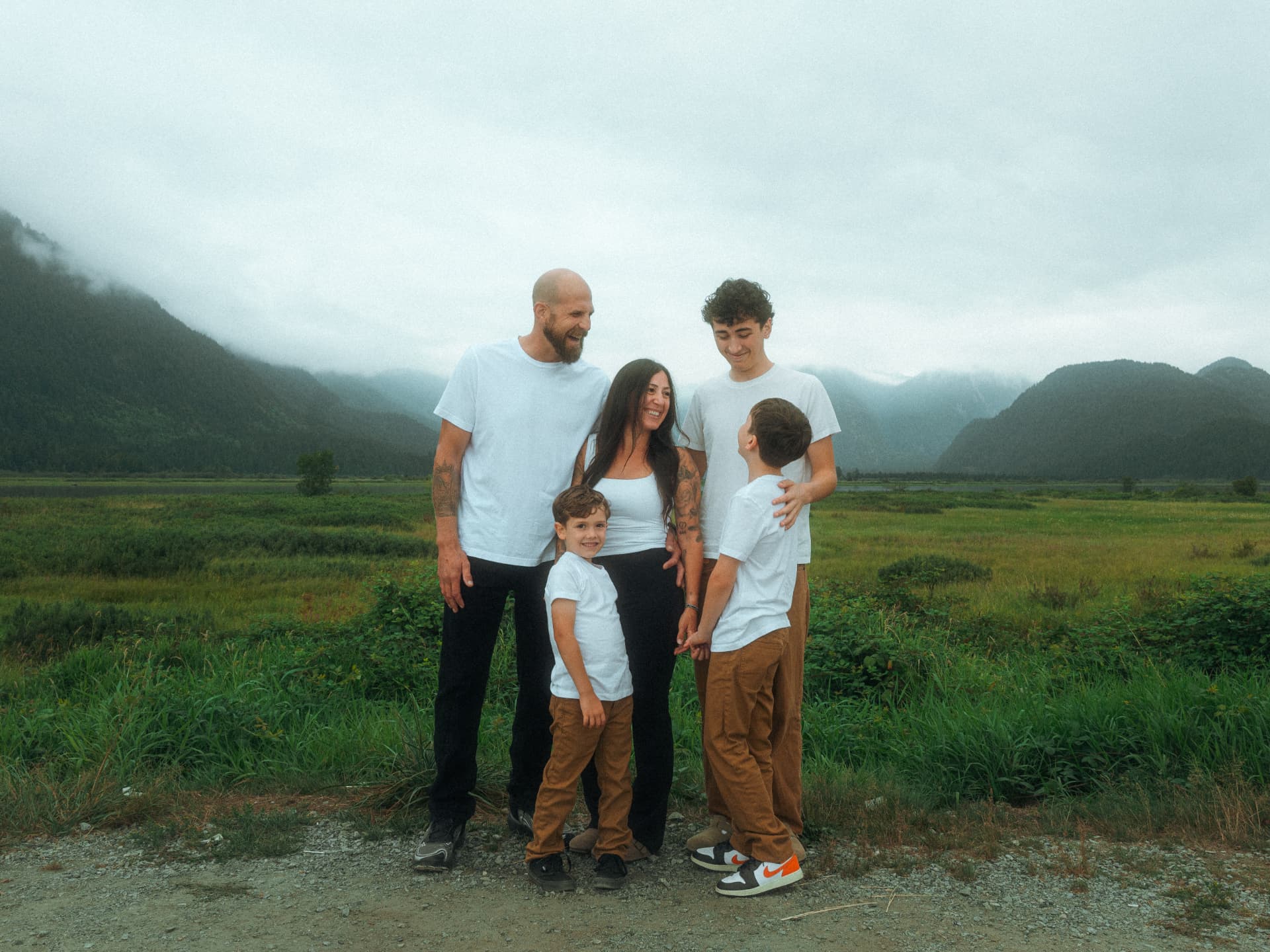 Family of five posing together in a misty mountain valley near Metro Vancouver